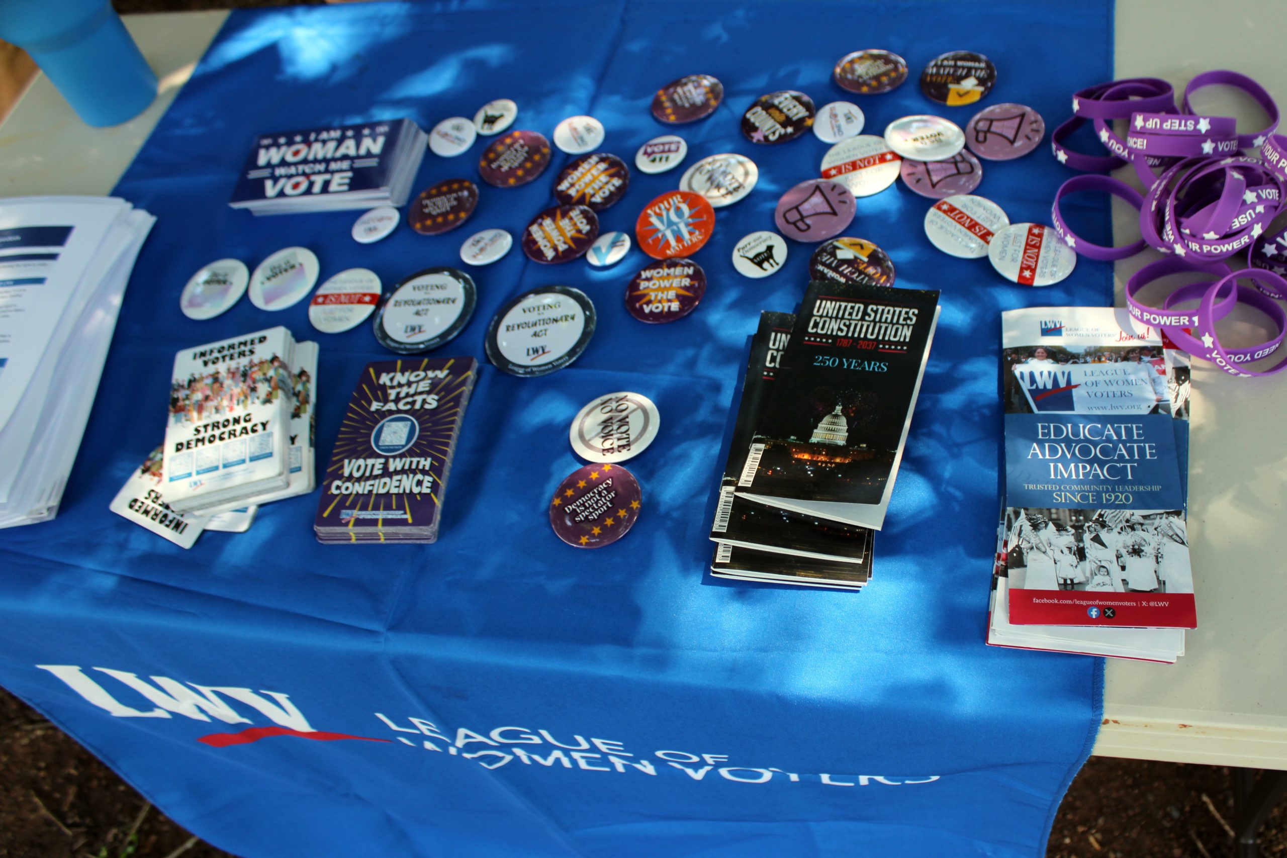 Voting rights buttons, bracelets, and civic engagement materials displayed on a table