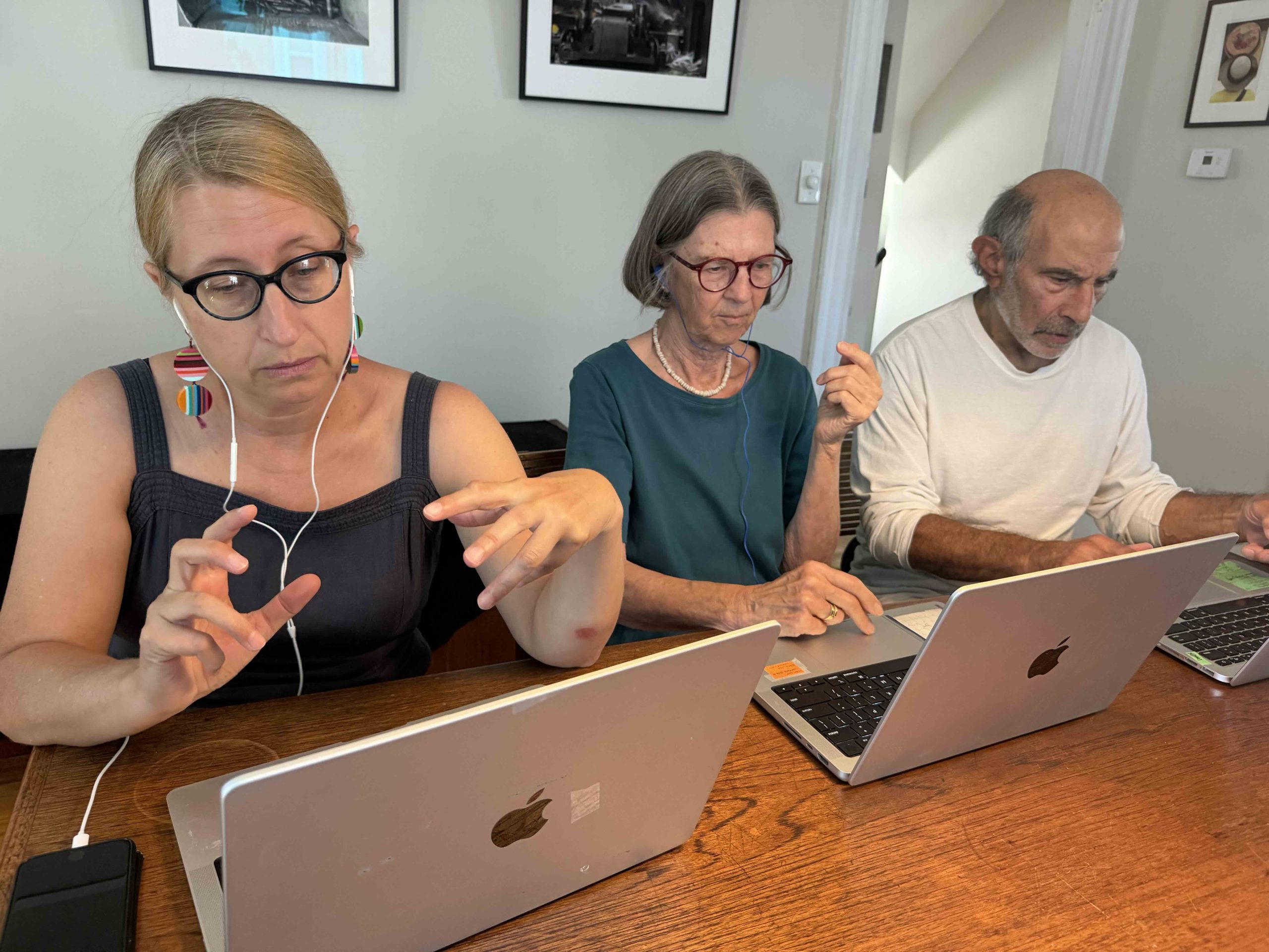 Three Bridge2Blue volunteers working together on laptops at a table
